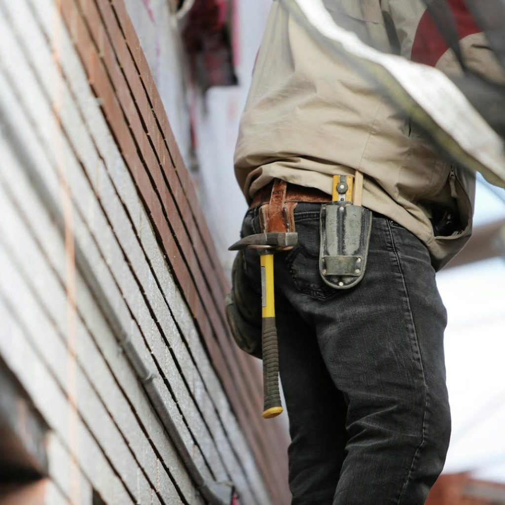 Man Wearing Black Denim Pants With Carrying Hammer on Holster